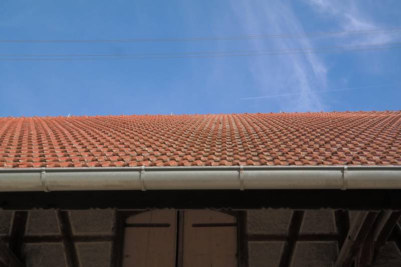 Étudier la différence entre une gouttière et un chéneau toiture pour rénover le système d'évacuation d'eau d'une copropriété à Cambrai.