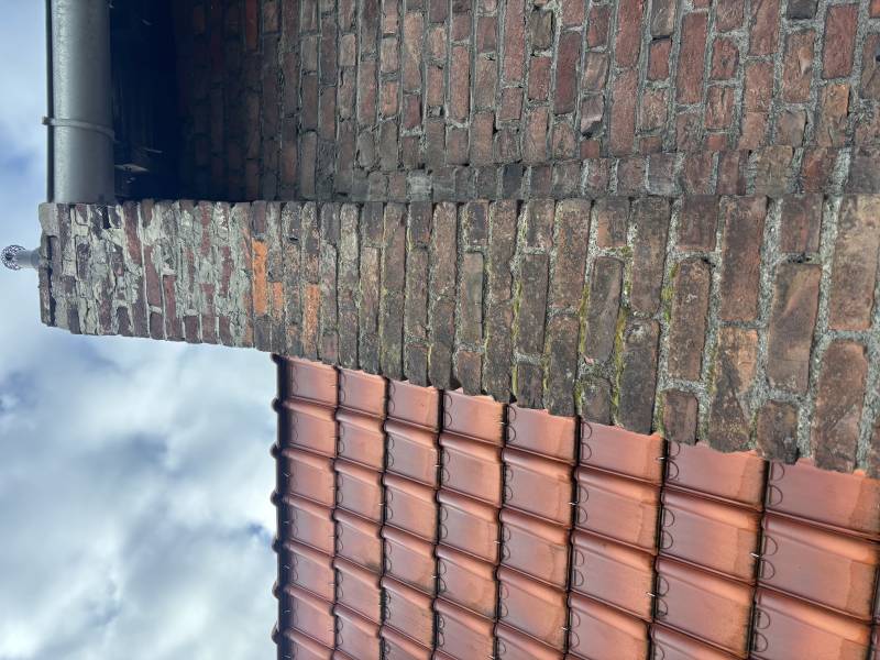 Rénovation de cheminée ancienne avec joint hydrofuge gris et nettoyage haute pression de la brique rouge à Lille dans le Nord