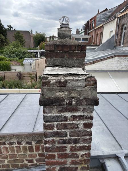 Chantier de remise en état sur une cheminée ancienne en briques : rénovation de cheminée avec chapeau béton et mortier hydrofuge à Lille